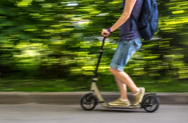 erkek bir scooter yolun aşağısında, bulanık adam hızda sürmek