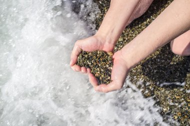 kalp sembol siyah bir arka plan üzerinde bir el içinde taşlar 