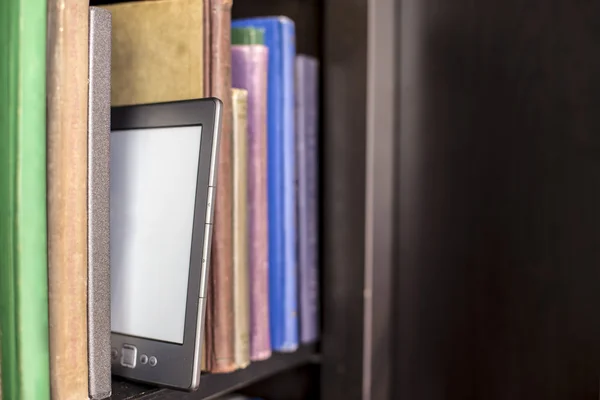 Електронна книга стоїть на дерев'яній книжковій полиці — стокове фото