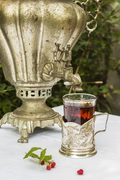 Vintage copper samovar in a cup holder and a glass of hot tea cl — Stock Photo, Image