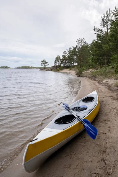 Kayak con pagaie su una spiaggia sabbiosa, sul lago. Stile di vita. — Foto Stock