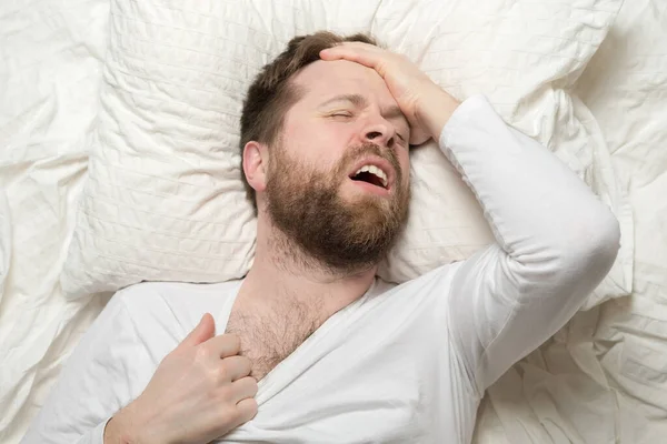 Stock image Insomnia. Young man cannot sleep, he is stuffy and has a headache. Mental health concept. 