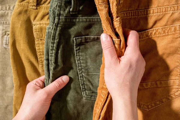 Las manos tocan los pantalones de pana acostados en el mostrador. Compras. —  Fotos de Stock