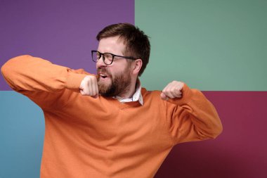 Komik beyaz adam zaferden gerçekten zevk alıyor, garip dansları var ve gözleri kapalı şarkı söylüyor. Renkli arkaplan.