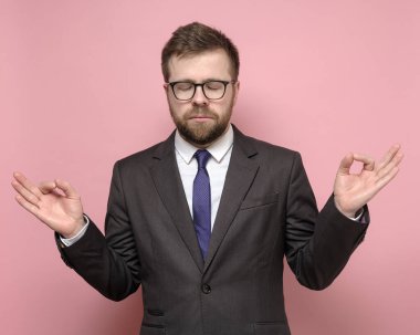 Takım elbiseli bir adam gözlerini kapattı ve meditasyon yaptı. Önemli bir kontrata girmeden önce uyum ve denge sağlamaya çalıştı.. 