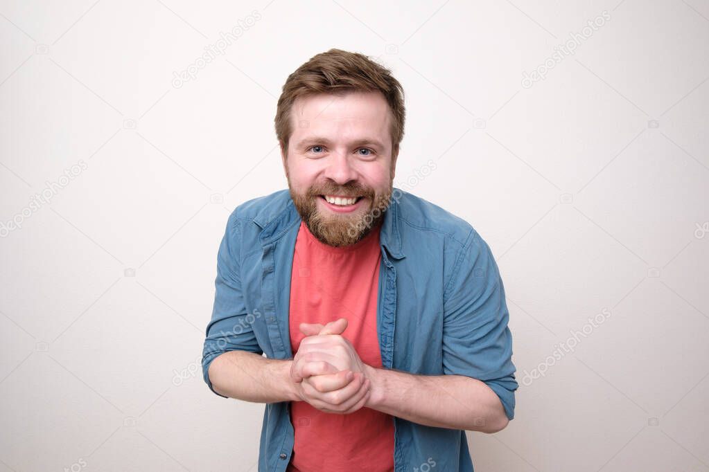 Happy bearded Caucasian man in casual clothes smiling and looking friendly. White background.