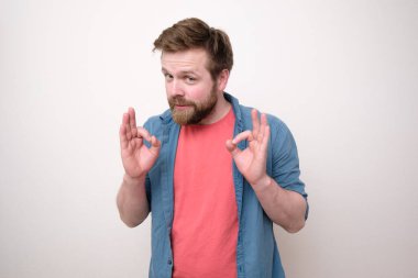 Sıradan giyinmiş bir adam birini sakinleştirmeye çalışır, ısrarla iyi bir jest yapar ve ikna edici görünür. Beyaz arkaplan.