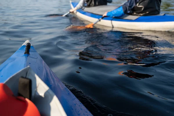 Los turistas en kayaks van en el agua suave del lago, en un día soleado de verano. Actividades de ocio y deportes. — Foto de Stock