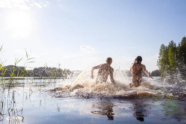 Grappige man en vrouw zwemmen en hebben plezier in een schoon bosmeer op een hete zomerdag. Actief toeristisch leven. — Stockfoto