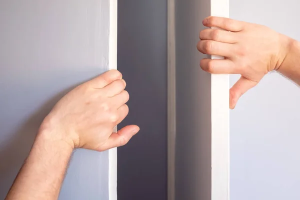 Las manos masculinas abren la puerta del armario en la habitación. —  Fotos de Stock