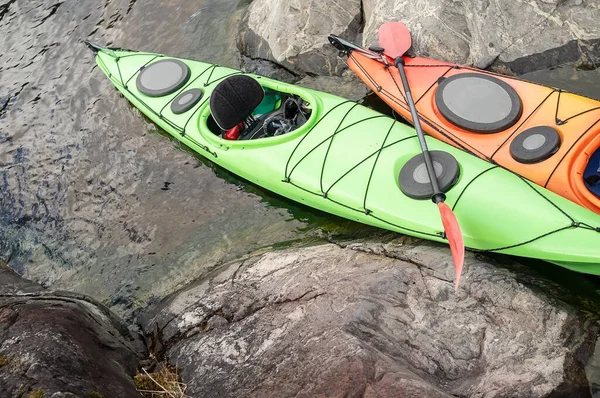 Deux kayaks stationnés sur la rive rocheuse du lac. Saison d'ouverture. Vue du dessus. — Photo