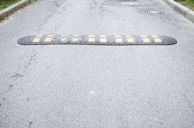 Asfalt yolda sarı ve siyah hız tümsekleri. Yayaların hız ve güvenliğini azaltmak için araçların önünü kesin..