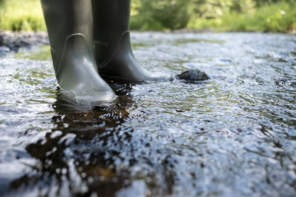 Suya dayanıklı erkek ayakları nehir boyunca yürür, yeşilliğin arka planına karşı, bir yaz gününde.. — Stok fotoğraf