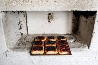 Rus sobasında, ahşap bir kesme tahtasının üzerinde böğürtlenli lezzetli turtalar var. Geleneksel mutfak.