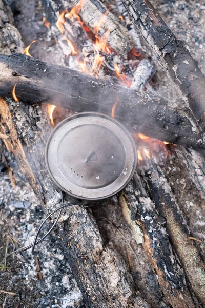 Γλάστρα της προετοιμασίας των τροφίμων στέκεται στα κάρβουνα φωτιά κάμπινγκ, κατασκήνωση, καλοκαιρινή μέρα. Άνω όψη. — Φωτογραφία Αρχείου