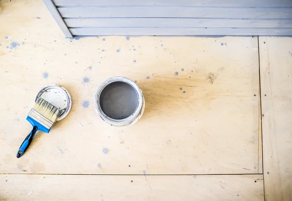 Öppna paint burkar och en pensel på golvet — Stockfoto