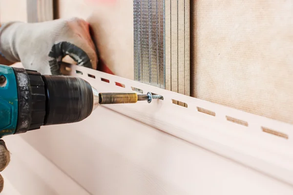 Man screws in a wall — Stock Photo, Image