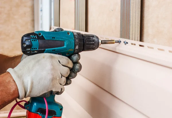 Man screws in a wall — Stock Photo, Image