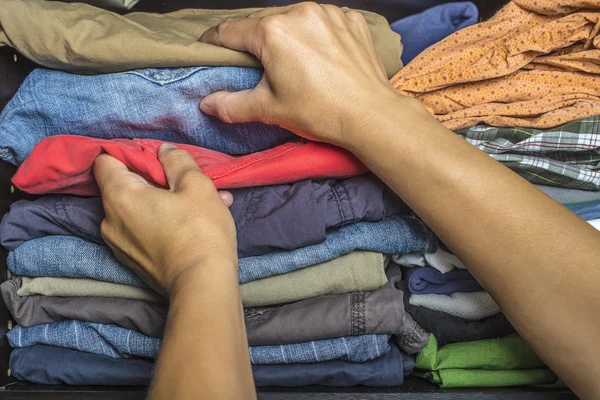 As pessoas tiram as roupas do armário. — Fotografia de Stock