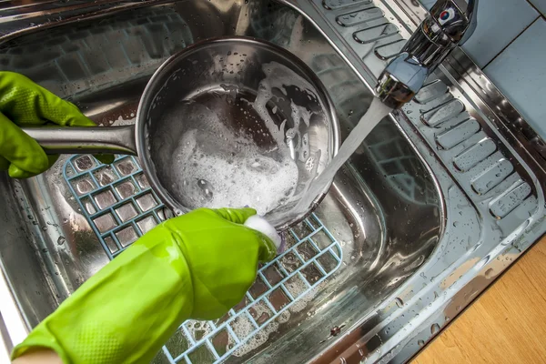 Mann spült Geschirr in der Spüle — Stockfoto