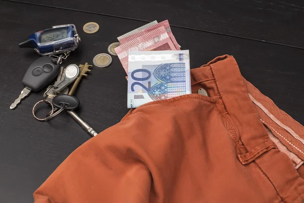 Euro-Papiergeld und Münzen fielen aus seiner Tasche auf den Tisch, auf dem die Schlüssel lagen — Stockfoto