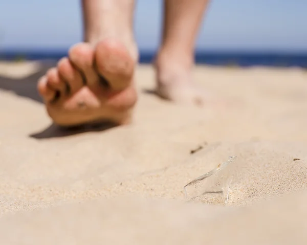 Man går på stranden och risken att trampa på en utbrytargrupp av trasig flaska glas — Stockfoto