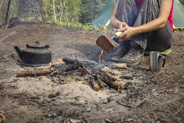 캠핑 하는 동안 앉아 근처가 열 화재와 뜨거운 차를 마시는 — 스톡 사진