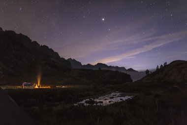 Kamp ateşi etrafında gece turistler ve avcılar ısıtmalı