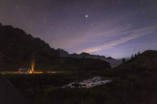 Kamp ateşi etrafında gece turistler ve avcılar ısıtmalı — Stok fotoğraf