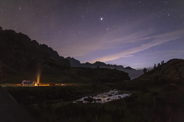 Kamp ateşi etrafında gece turistler ve avcılar ısıtmalı