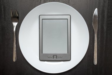 E-kitap bırakır gıda yerine beyaz bir plaka üzerinde