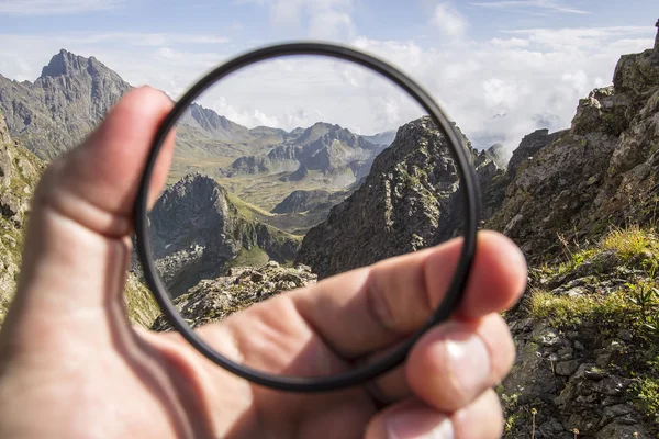 Ruka klade transparentní čistý ochranný Uv filtr k fotoaparátu — Stock fotografie