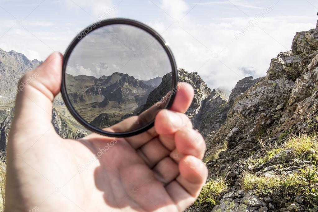 Hand puts a polarization filter to the camera Stock Photo by ©akoldunov