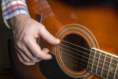 adam gitar çalıyor, parmak dizeleri koparıp.