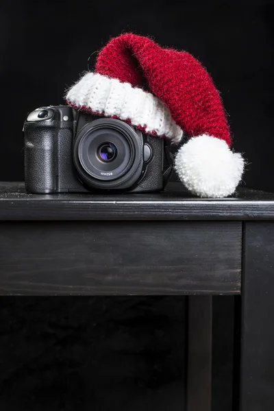 DSLR fotocamera in un cappello rosso di Natale di Babbo Natale — Foto Stock