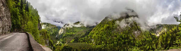 Viejo camino serpenteante va en las pintorescas montañas — Foto de Stock