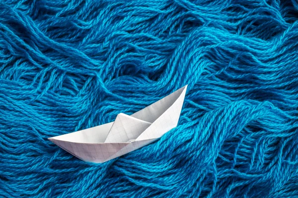 Carino bianco di origami barca galleggiante sulle onde del filato — Foto Stock