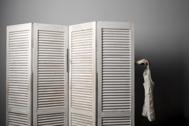 Oda durak ve yerine soyunma içinde kadın kolu bir elbiseye tutar. 