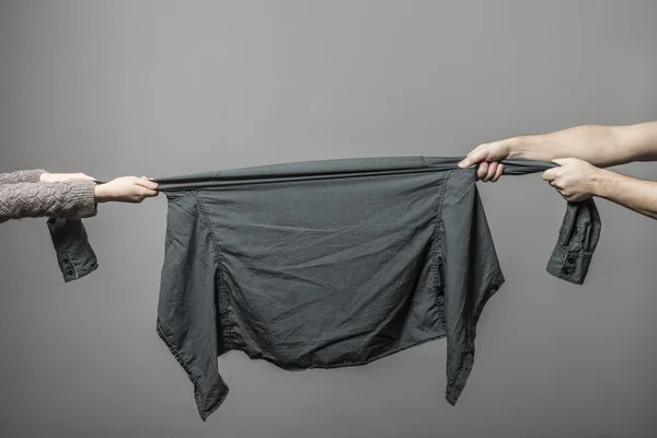 Man and woman hungrily snatch each other's hand clothes at the t — Stock Photo, Image