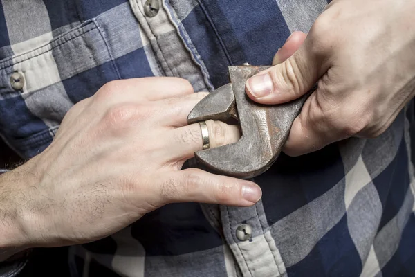 Remove wedding ring from the finger using a monkey wrench — Stock Photo, Image