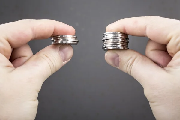 Zeiger vergleichen zwei Stapel von Münzen unterschiedlicher Größe — Stockfoto