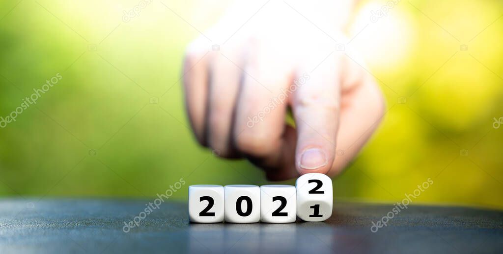 Hand turns dice and changes the year 2021 to 2022.