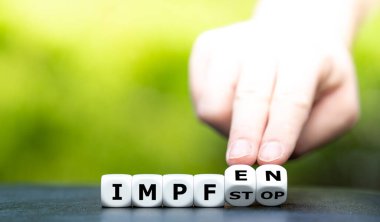 Avrupa 'daki gecikmiş covid 19 aşı stoğunun sembolü. El zarları döndürür ve Almanca 