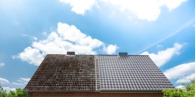 A half cleaned house roof shows the before and after effect of a roof cleaning.	
