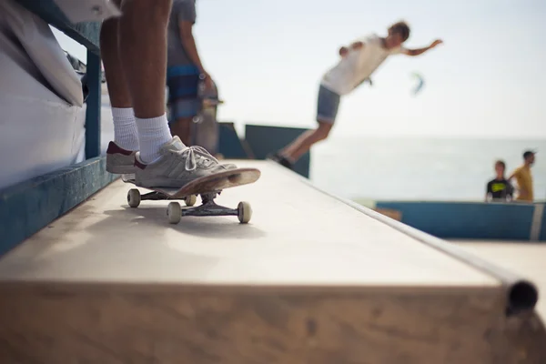 Ugrás a félcső skatepark fiatal deszkások — Stock Fotó