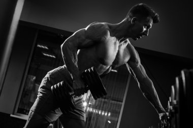 Tek kollu satır egzersiz yapan erkek