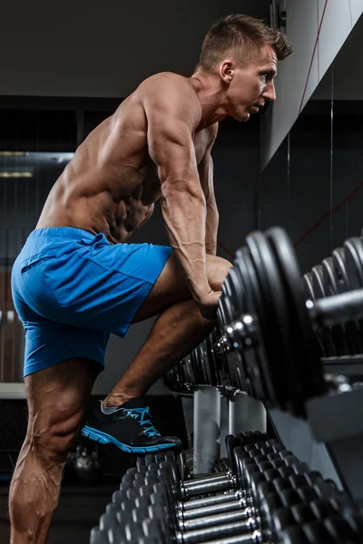 Tipo en el gimnasio cerca de pesas — Foto de Stock