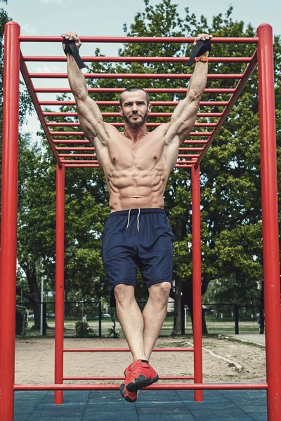 Uomo che fa pull-up su barra orizzontale — Foto Stock