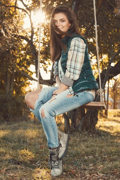 Dívka s houpačkou na podzimní park — Stock fotografie