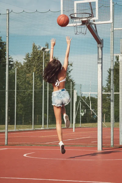 Frau spielt auf Basketballplatz — Stockfoto
